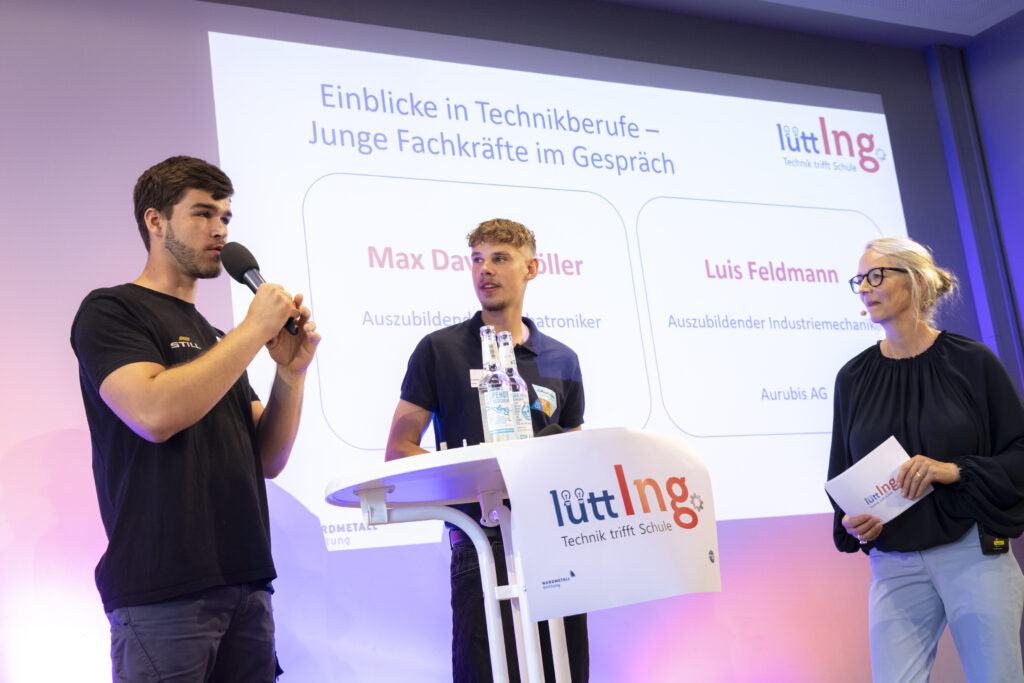 Zwei Auszubildende berichten im Gespräch mit der Moderatorin bei der lüttIng.-Abschlussveranstaltung über technische Berufe und ihren Ausbildungsalltag.